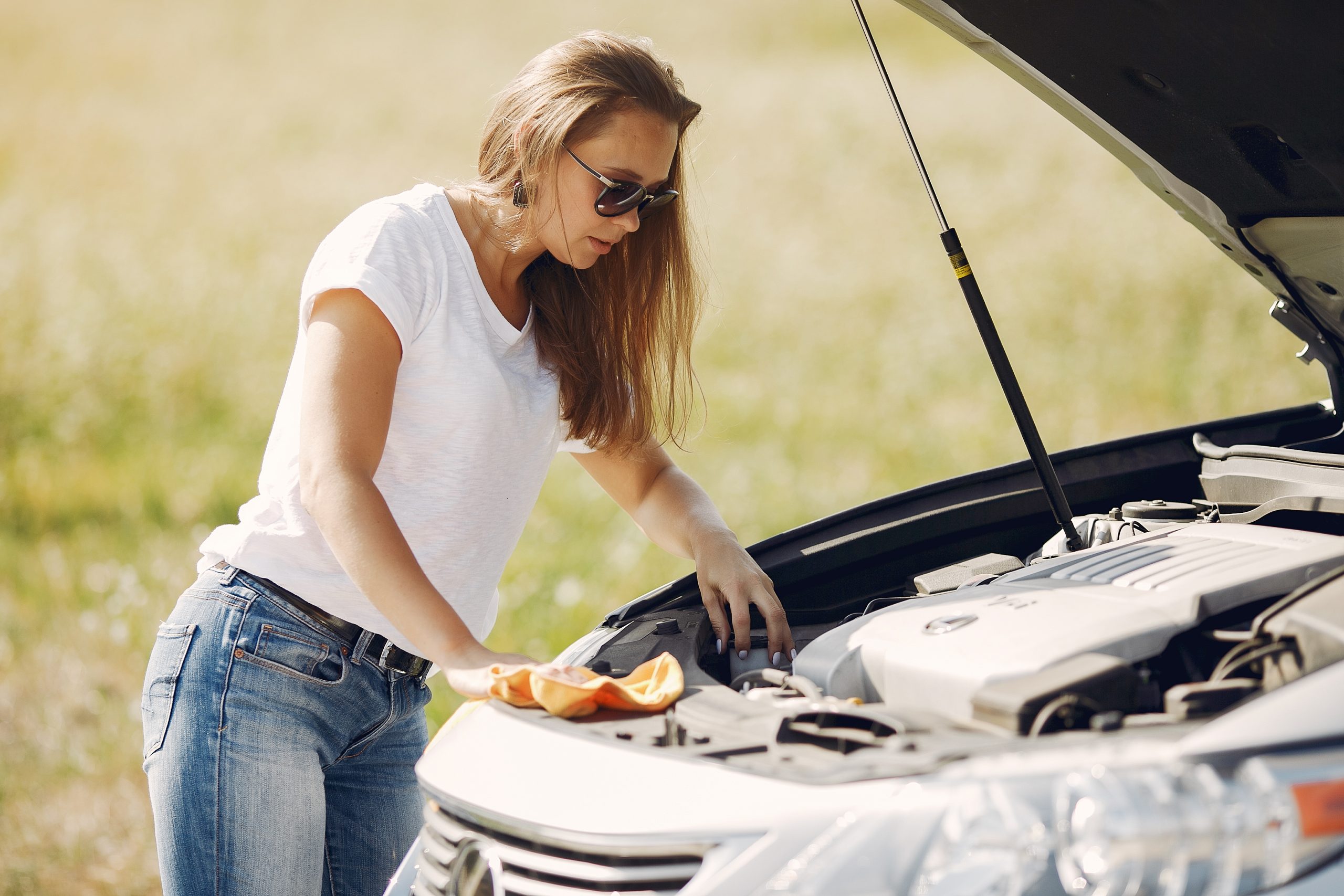 Woman inspecting her car battery